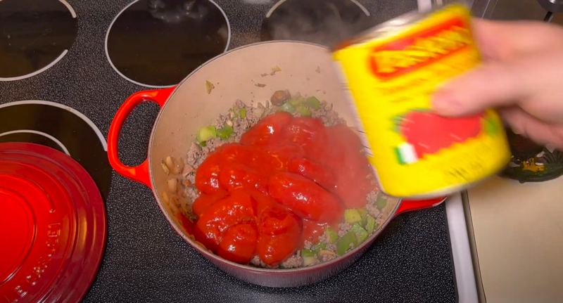 Add the whole tomatoes, tomato sauce, tomato paste, minced garlic, and water.